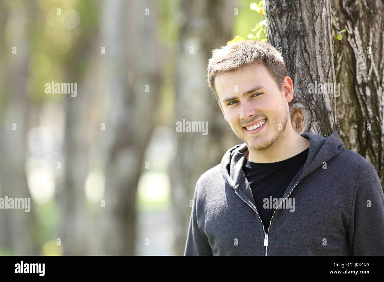 Porträt einer stattlichen Teenager boy Posing suchen Sie in einem Park im Freien Stockfoto