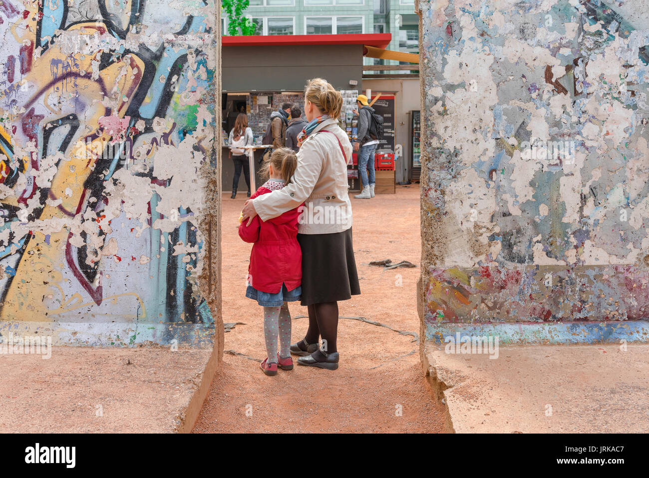 Mutter und Tochter, Eltern und Kind - Mutter und Tochter - posieren zwischen zwei Teilen der Berliner Mauer im Mauermuseum, Berlin, Deutschland Stockfoto