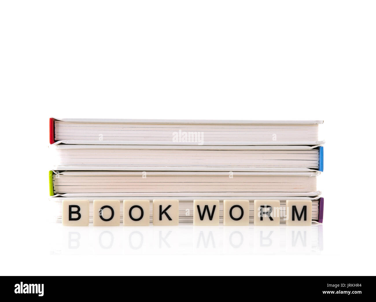 Stapel Bücher mit Bookworm buchstabiert mit Word Fliesen auf weißem Hintergrund Stockfoto
