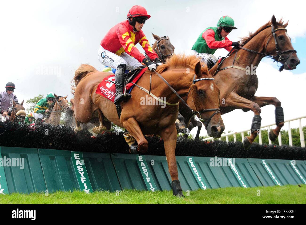 Aydoun und Jockey Bryan Cooper gehen auf Sieg gewinnen O'Leary Versicherungen Maiden Hurdle während Super Samstag des Sommerfestivals Galway in Galway Racecourse. Stockfoto