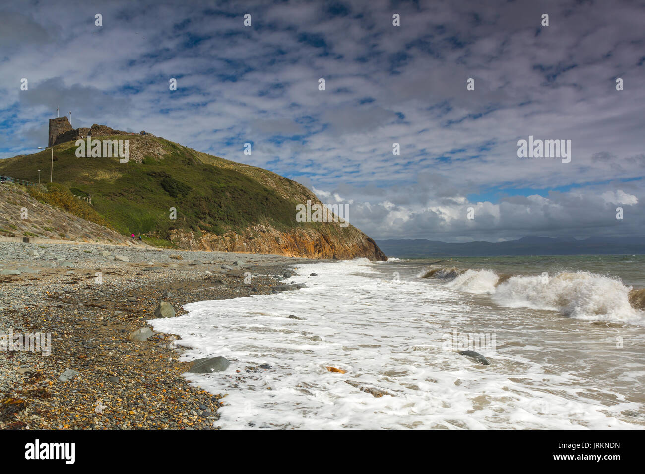 Der Strand am Schloss in Criccieth, North Wales, während einer Flut an einem hellen Sommertag Stockfoto