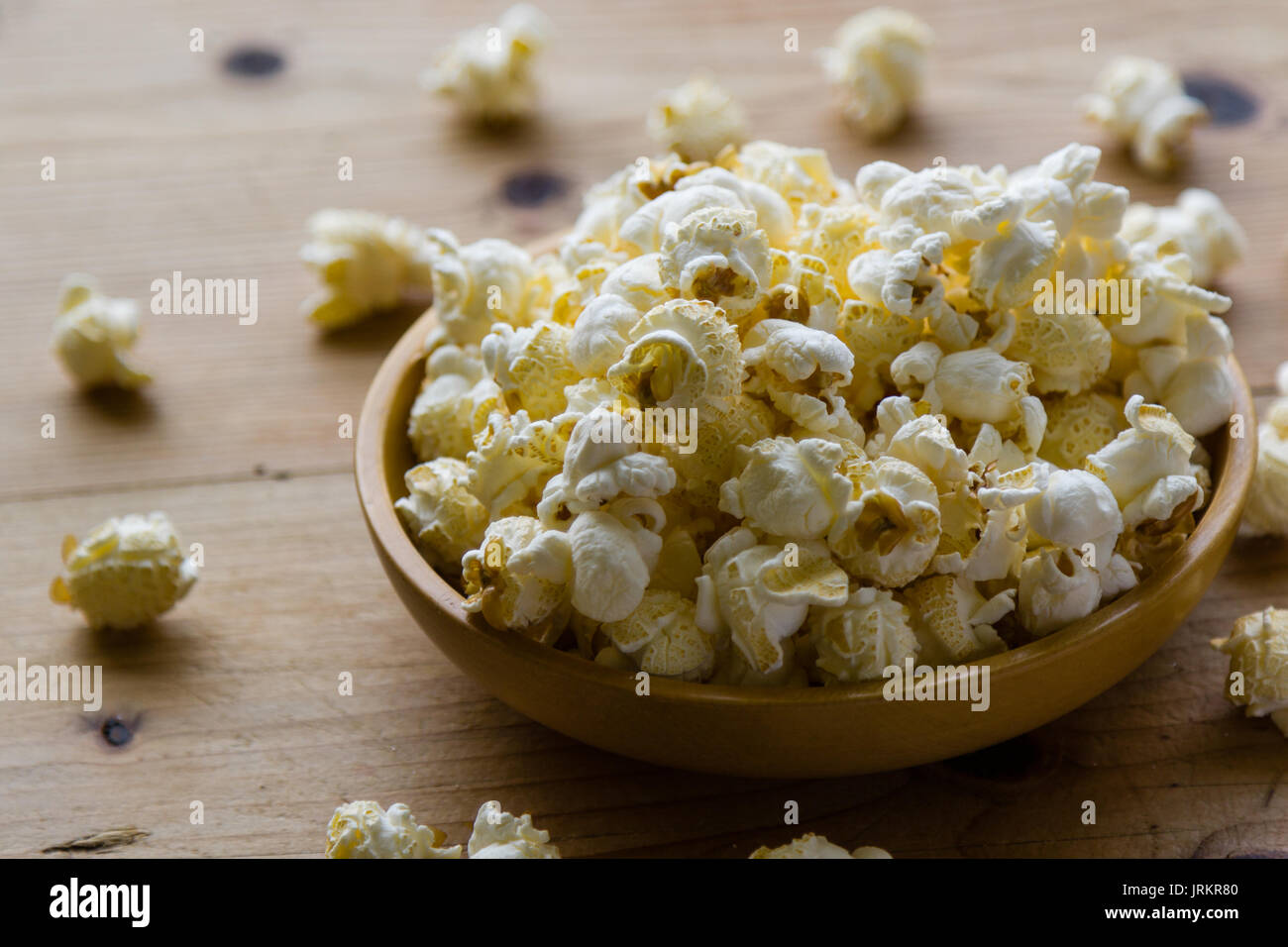 Frisch gesalzen Popcorn in Schale auf Holztisch Stockfoto