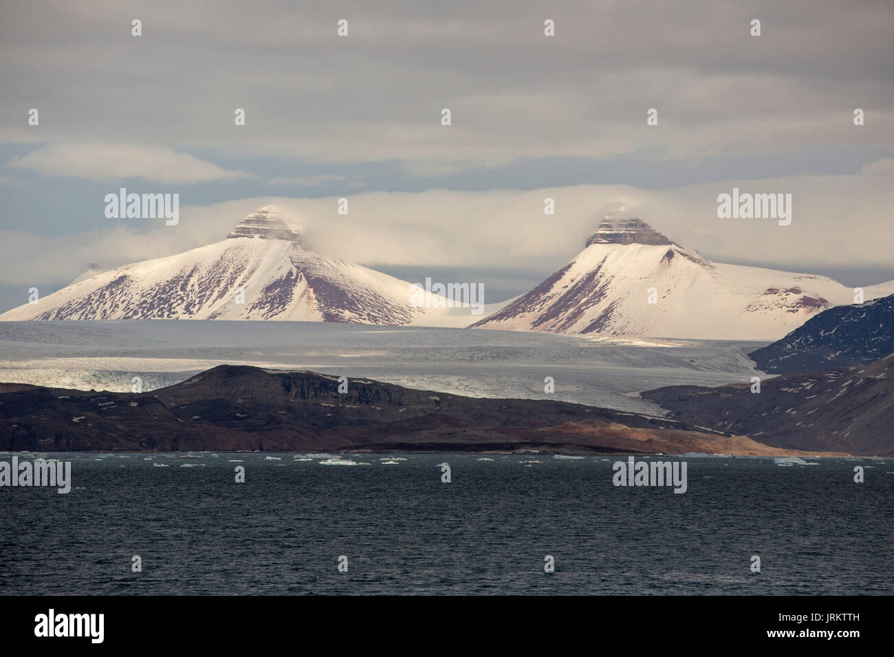 Kronebreen oder Krone Gletscher, Kongsfjord und Schnee bedeckt, pyramidal geformte Berge. Im Juni, Spitzbergen, Svalbard, Norwegen genommen Stockfoto