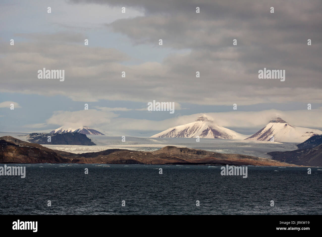 Kronebreen oder Krone Gletscher, Kongsfjord und Schnee bedeckt, pyramidal geformte Berge. Im Juni, Spitzbergen, Svalbard, Norwegen genommen Stockfoto