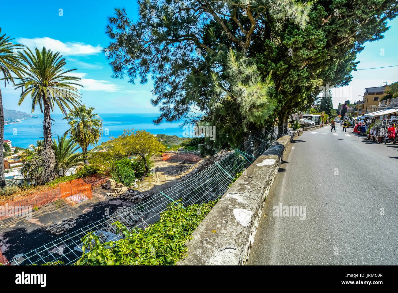 Einen sonnigen Sommertag in Taormina Italien Sucht nach unten von der Hauptstraße auf die Küste und das Mittelmeer unter Stockfoto