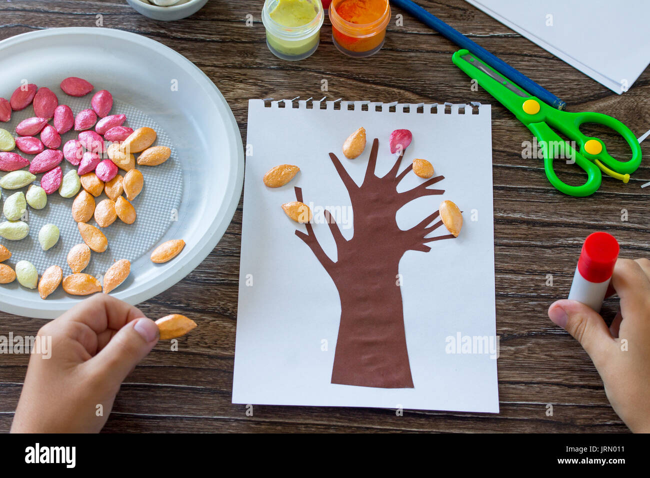 Das Kind Klebstoffe die Details der Anwendung. Postkarte Herbst Baum mit bunten Blättern der Kürbis verlässt. Kinder- Kunst, Handwerk für Ch Stockfoto