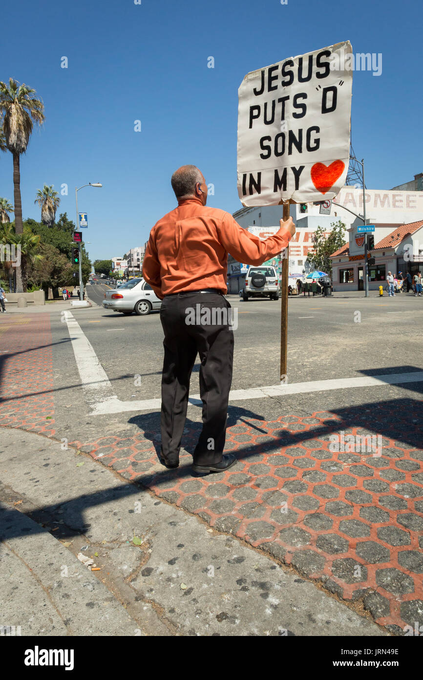 Mann in Westlake, Los Angeles, mit Zeichen, liest, "Jesus' Lied in meinem Herzen" Stockfoto