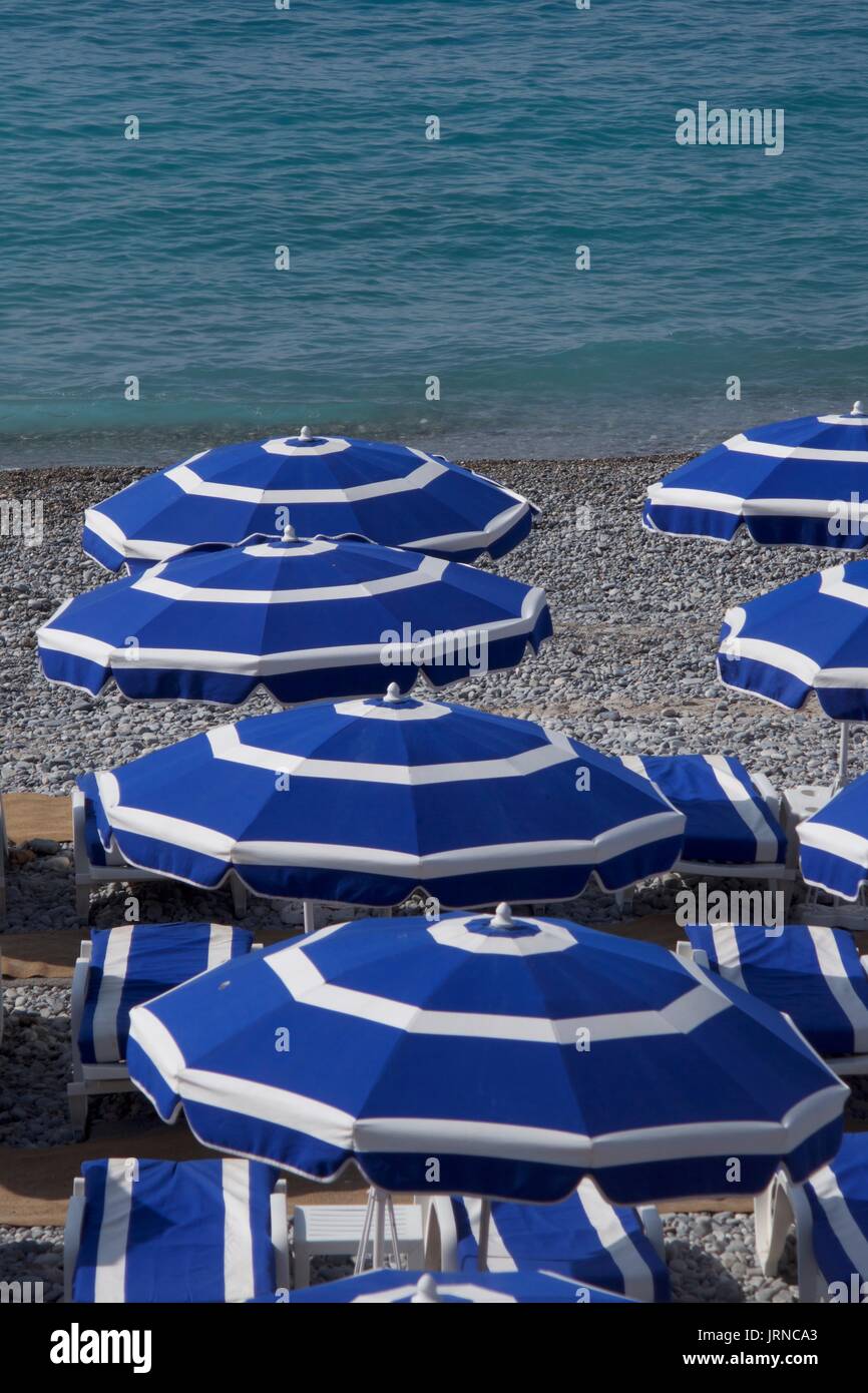 Blaue Sonnenschirme am Strand, Nizza, Frankreich Stockfoto