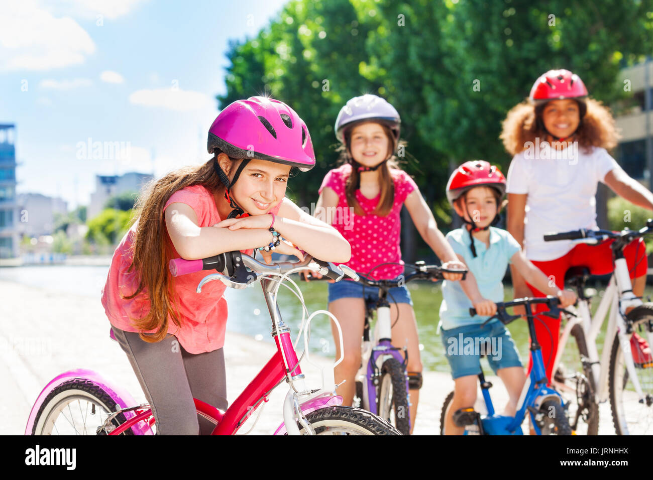 Portrait von 11-12 Jahre alten Mädchen in rosa Schutzhelm mit Fahrrad und warten auf Ihre Freunde Stockfoto