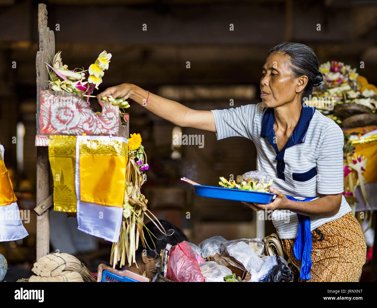 Sukawati, Bali, Indonesien. 3. August 2017. Eine Frau macht einen täglichen Hindu vor ihrem Geschäft auf dem lokalen Markt in Sukawati, Bali bietet. Balis lokale Märkte sind geöffnet täglich ein drei rotierenden Zeitplan, denn Verkäufern von Stadt zu Stadt reisen. Bevor moderne Kälte- und Convenience-Stores gemeinsamen Ort auf Bali wurde, wurden Märkte Gemeinschaftsversammlungen gedeihen. Weniger Menschen-Shop auf Märkten jetzt, da immer mehr Verbraucher zu Convenience-Stores und mehr Familien haben Kühlschränke. Bildnachweis: Jack Kurtz/ZUMA Draht/Alamy Live-Nachrichten Stockfoto