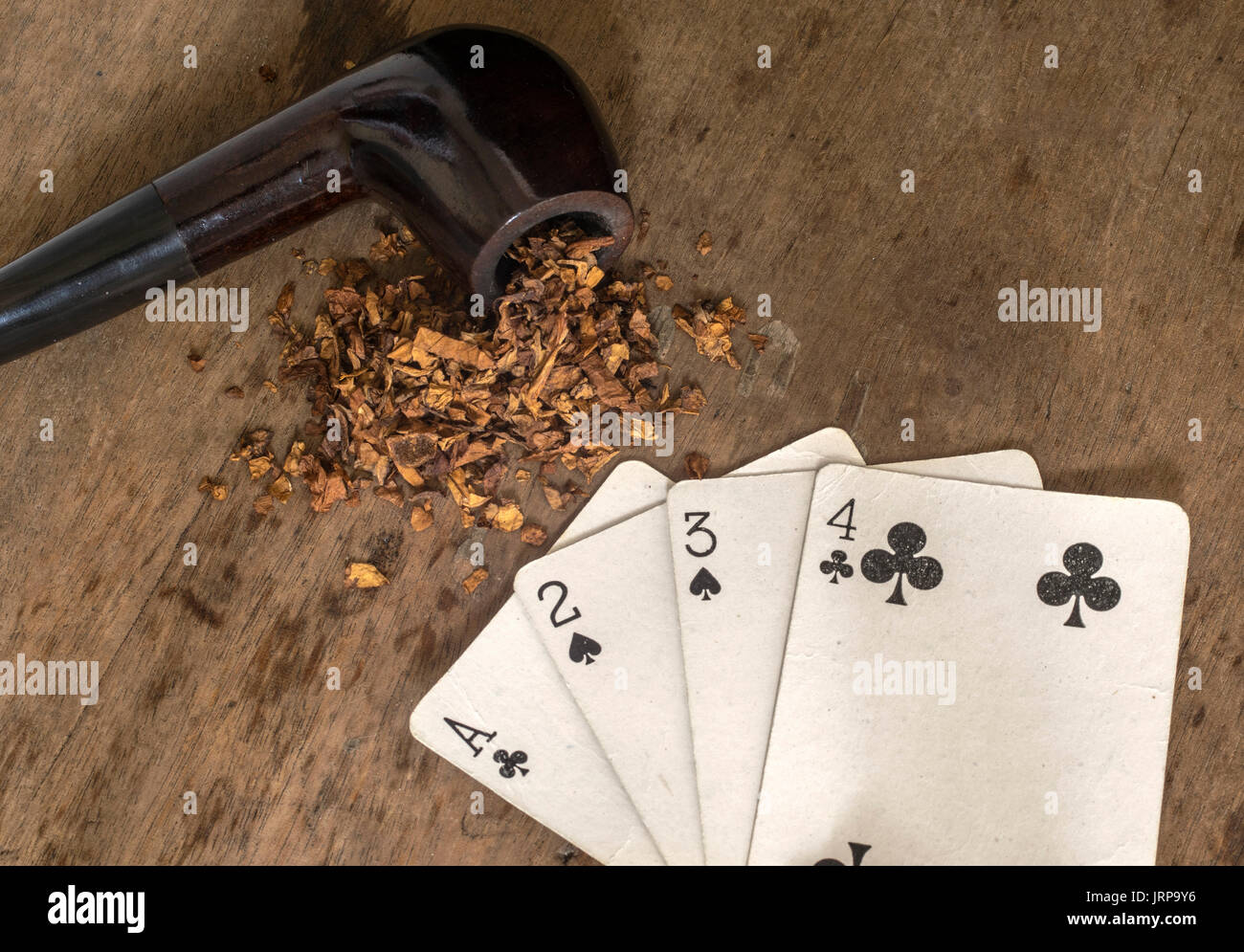 Verbreitung weiße Karten mit schwarzen Symbolen und einer Tabak rauchen Rohr auf einem Holztisch Oberfläche Stockfoto