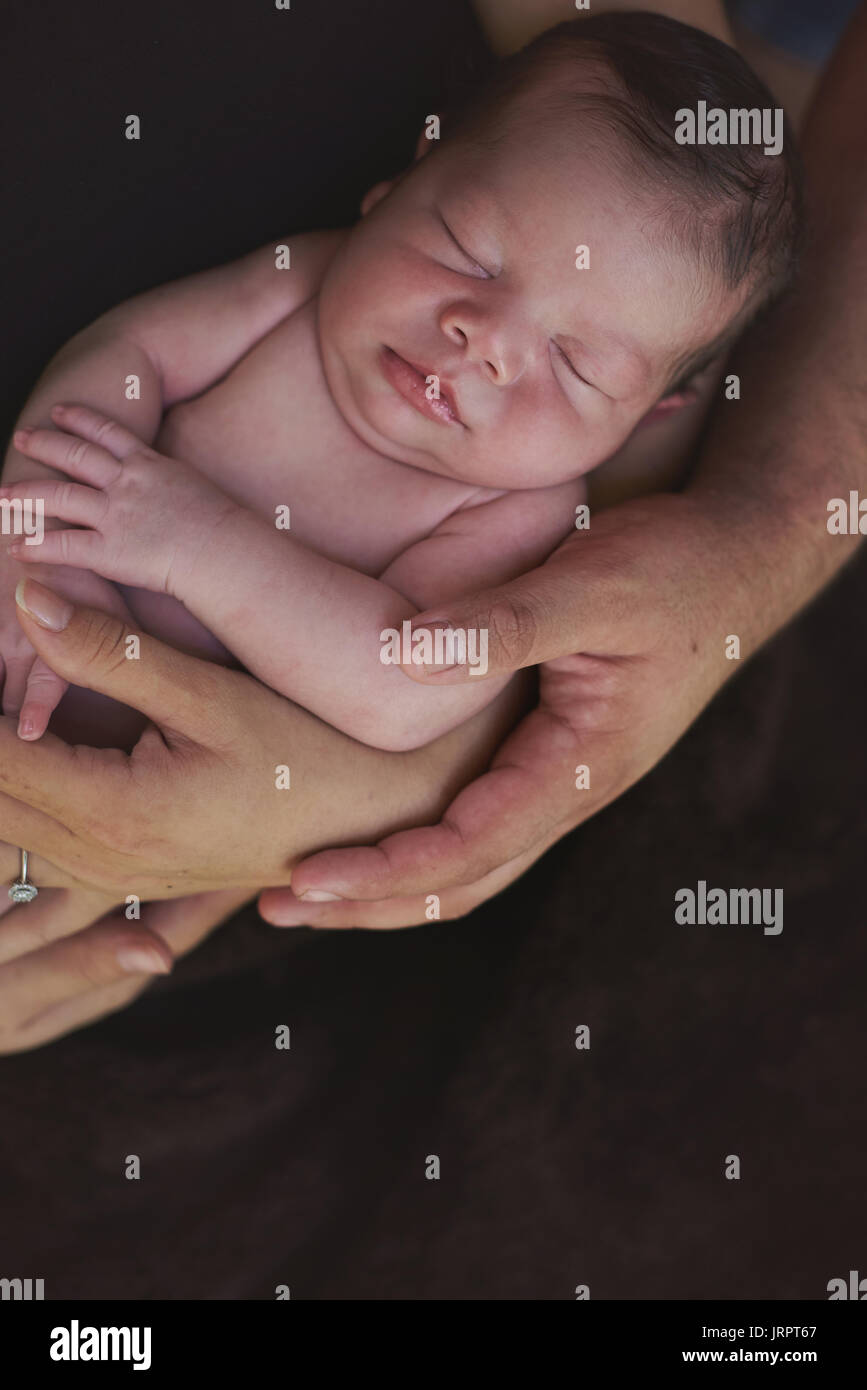 Eltern Hände halten kleines schlafendes Baby close-up Stockfoto