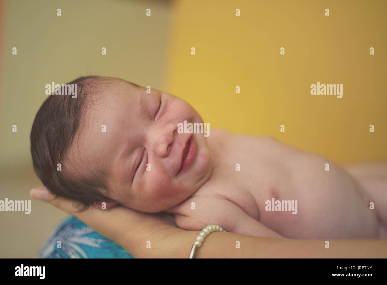 Lächelnd New Born Baby schlafen in übergeordneten Hände Stockfoto