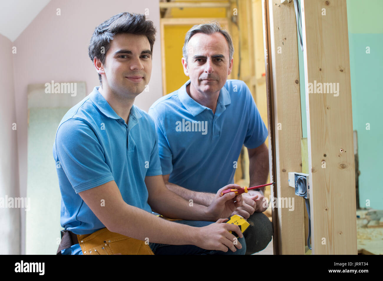 Portrait von Elektriker mit Lehrling Arbeiten im neuen Haus Stockfoto