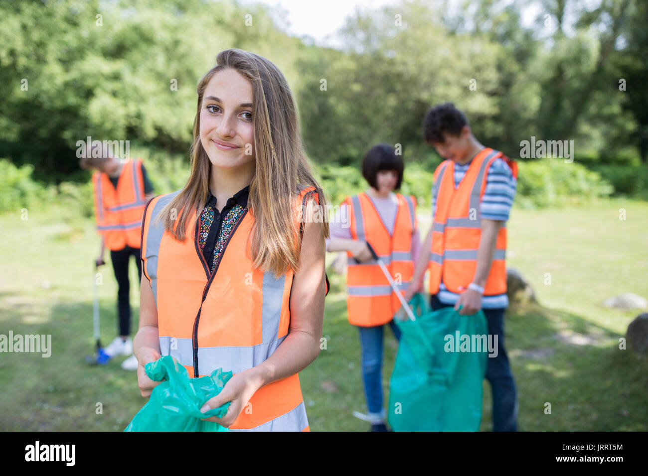 Gruppe von hilfreich Jugendlichen sammeln Müll In der Landschaft Stockfoto