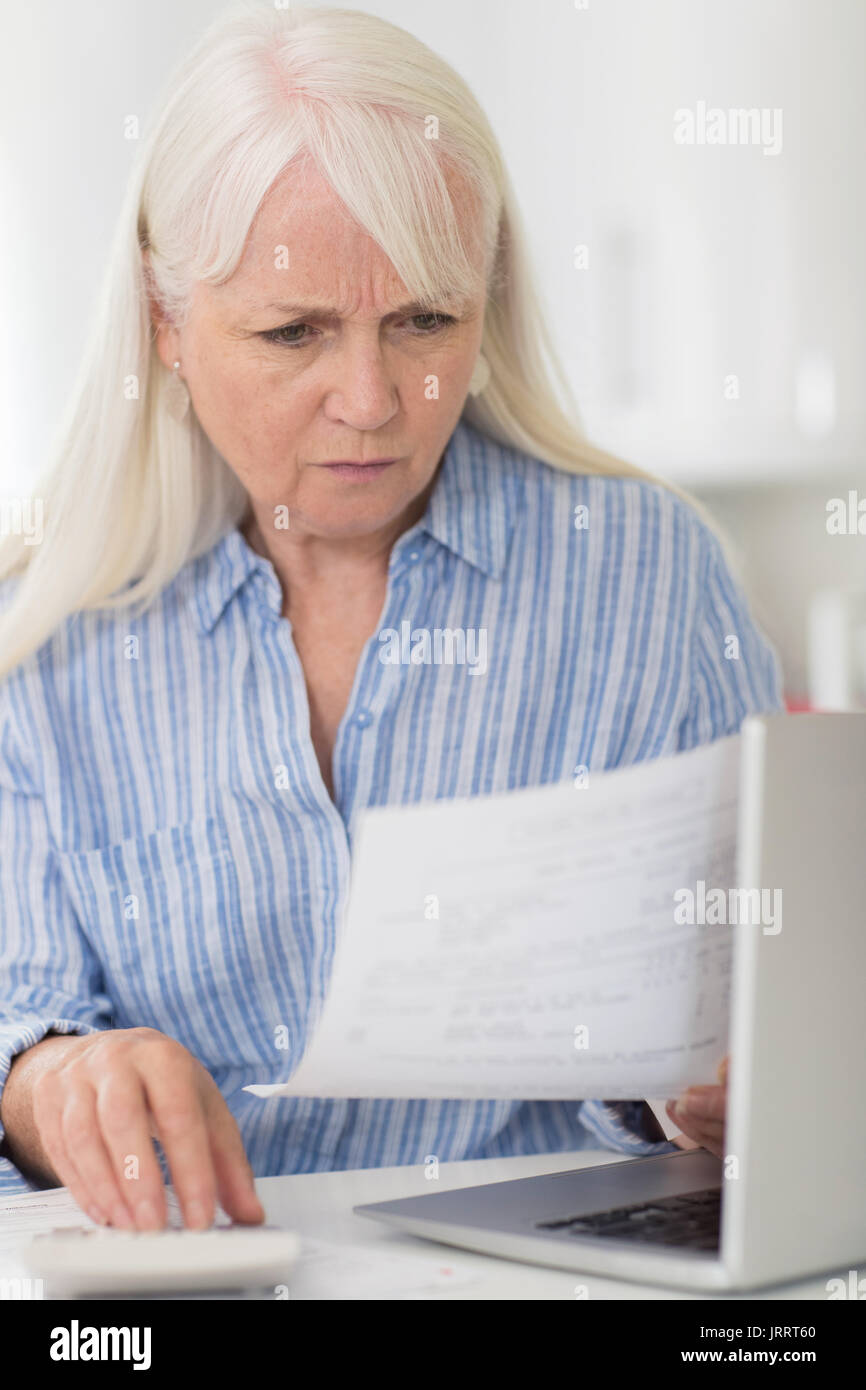 Besorgt reife Frau mit Laptop Berechnung Haushalt Finanzen Stockfoto