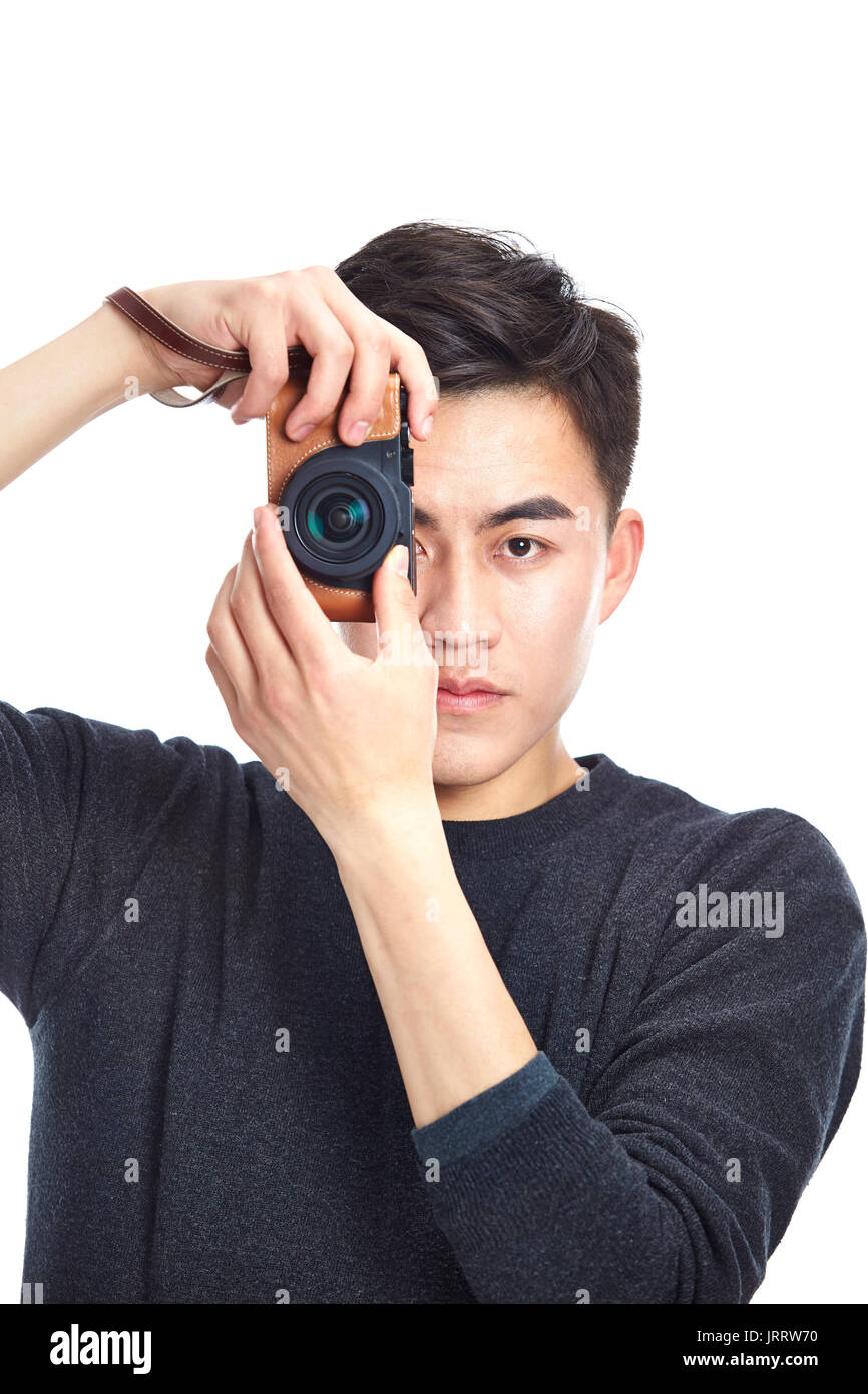 junge asiatische Mann eine Aufnahme mit Kamera, isoliert auf weißem Hintergrund. Stockfoto