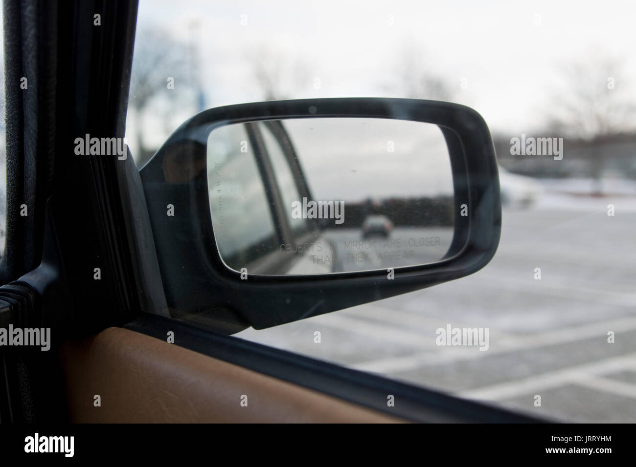 Blick auf den Rückspiegel lesen' Objekte im Spiegel näher sind, als sie erscheinen, auf geparkten Auto. Stockfoto