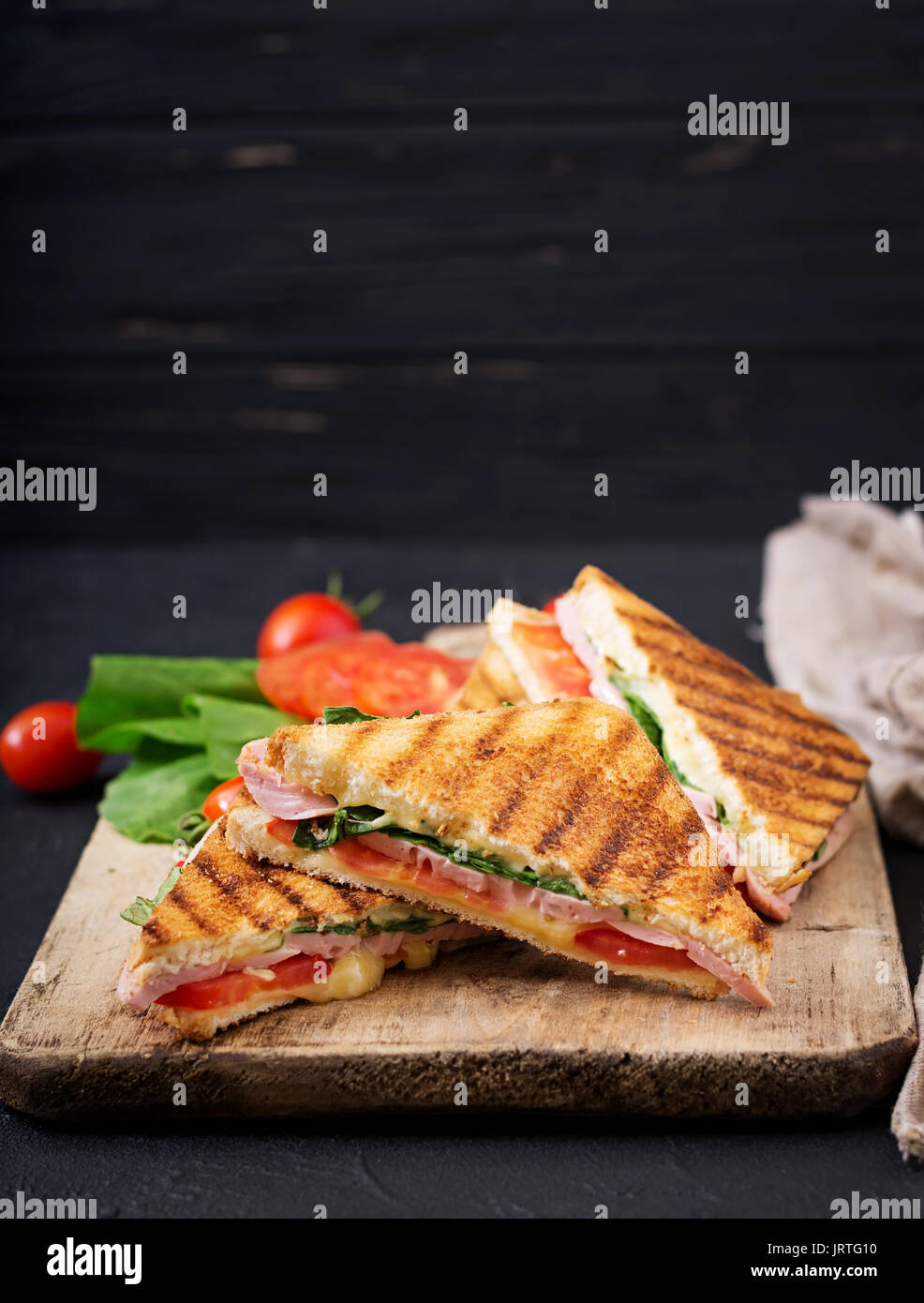 Club Sandwich Panini mit Schinken, Tomaten, Käse und Basilikum. Stockfoto