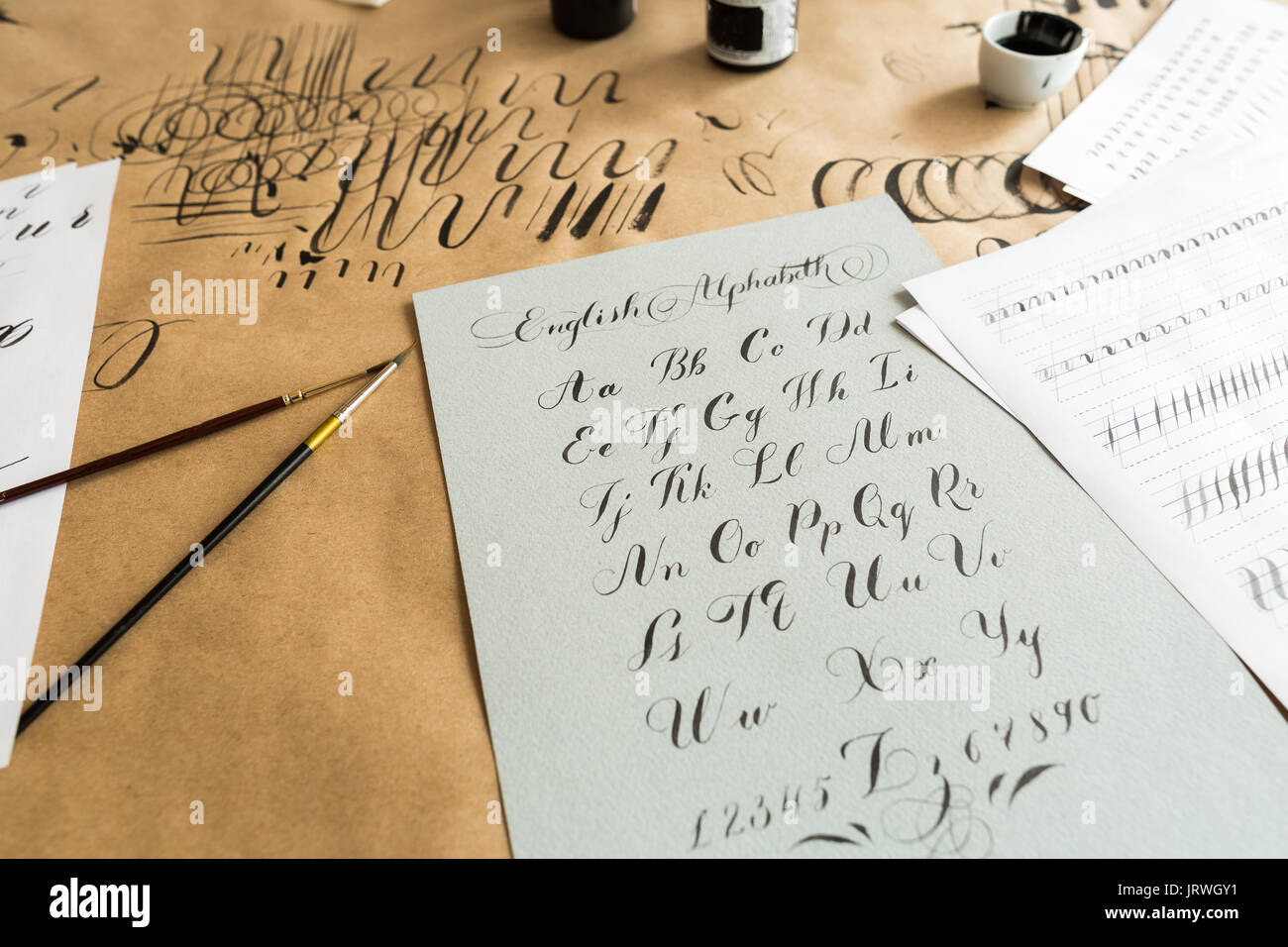 Malerei, Kreativität, dekorieren. einfache, aber schöne, harmonische Skript von Bekannten lateinischen Buchstaben auf dem grauen schwerem Papier mit schwarzer Tinte geschrieben Stockfoto