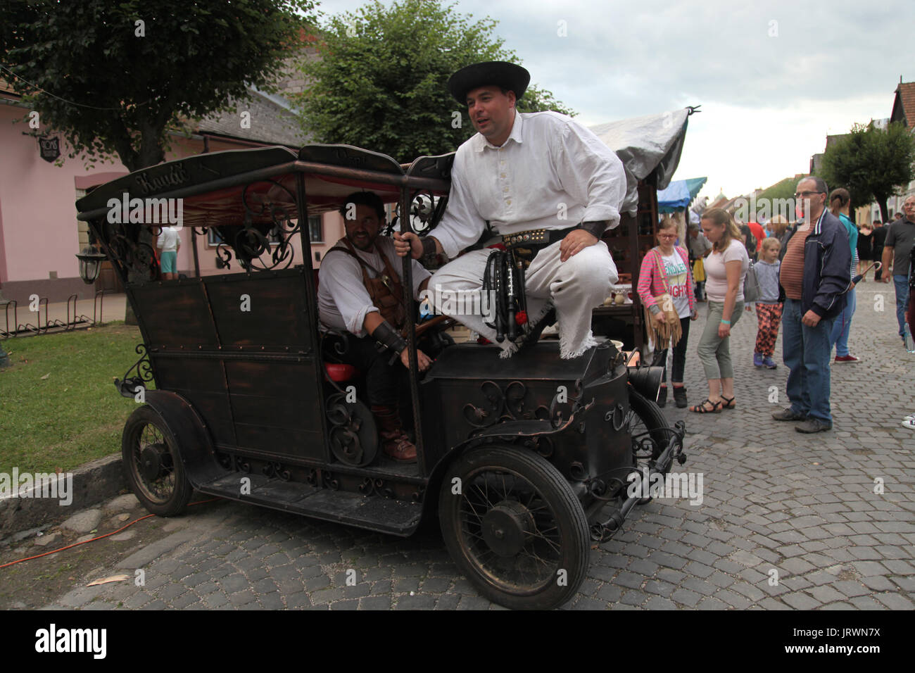 Smiths in der traditionellen slowakischen Kleidung mit ihren handgefertigten Auto von Metall an Die Europäische Folk- und craft-Festival, Kezmarok, Slowakei, gekleidet. Stockfoto