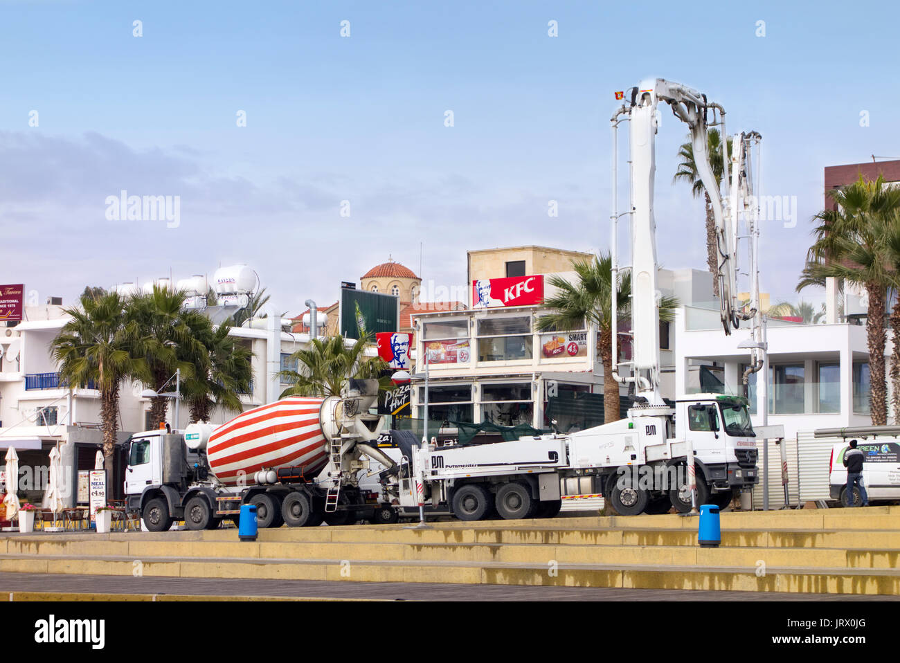 Paphos, Zypern - Dezember 20, 2013 Kran Auto und Betonmischanlagen Staplers Arbeiten auf der Baustelle in der Nähe von KFC-Restaurant in Paphos Straße. Städtische Szene. Stockfoto