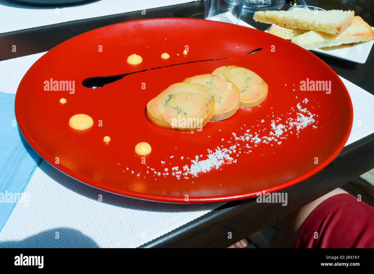 Drei Scheiben halb gebratene Gänseleber auf eine orange Teller serviert mit einer Verrundung Balsamico Essig in der Stadt Bar le Duc in der Meuse Française Stockfoto