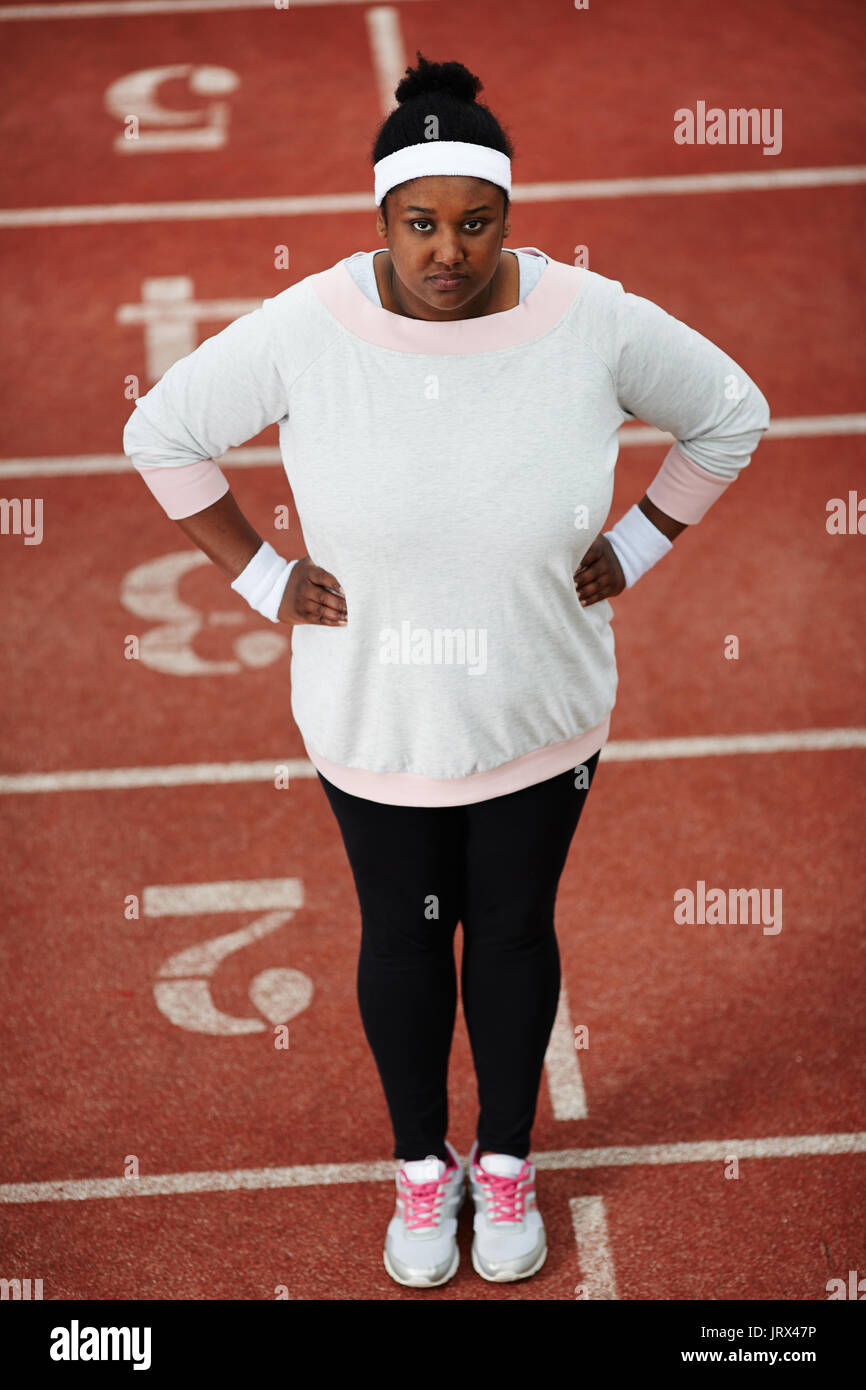 Mollige Frau in Sportkleidung auf der Laufstrecke mit ihren Händen auf den  Hüften Stockfotografie - Alamy
