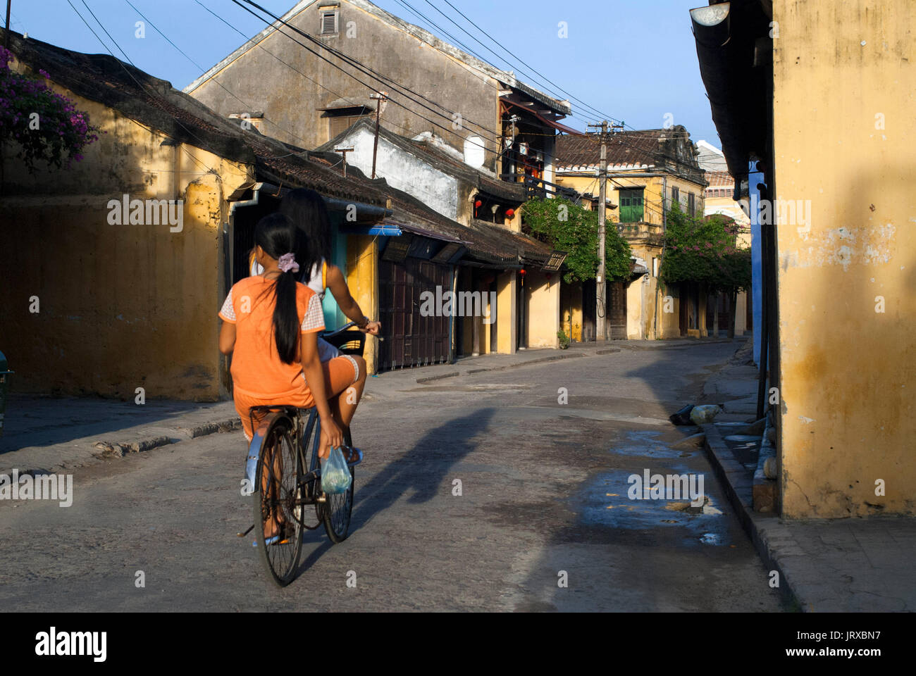 Vietnam, Quang Nam Provinz, Hoi An, die Altstadt, die als Weltkulturerbe von der unesco, traditionellen Haus aufgeführt. Bach Dang Street. Vietnam. Ein Mädchen auf dem Fahrrad. Stockfoto