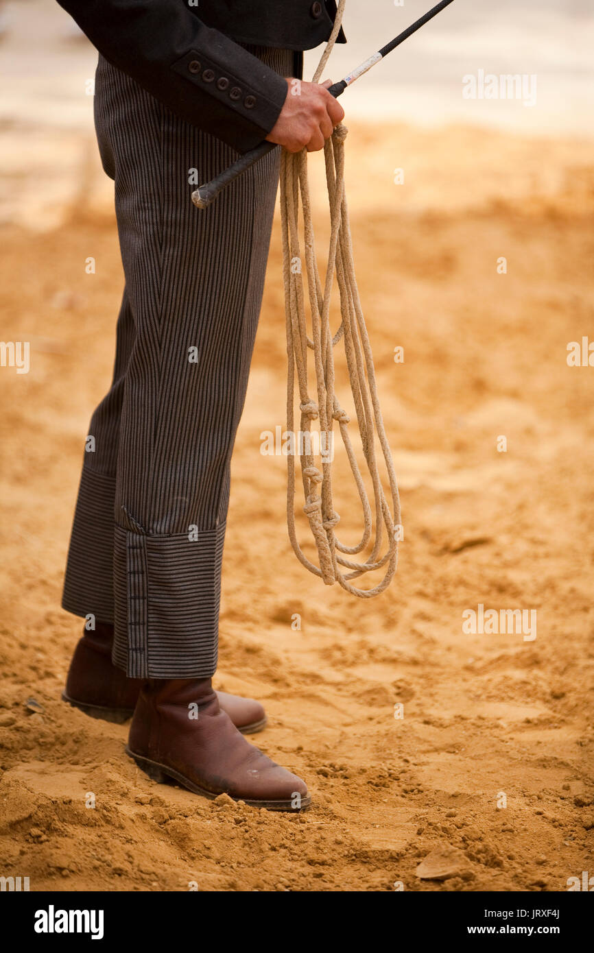 Cowboy während ein Reitzentrum Meisterschaft teilnehmen hält Seil und Peitsche in Andalusien, Spanien Stockfoto