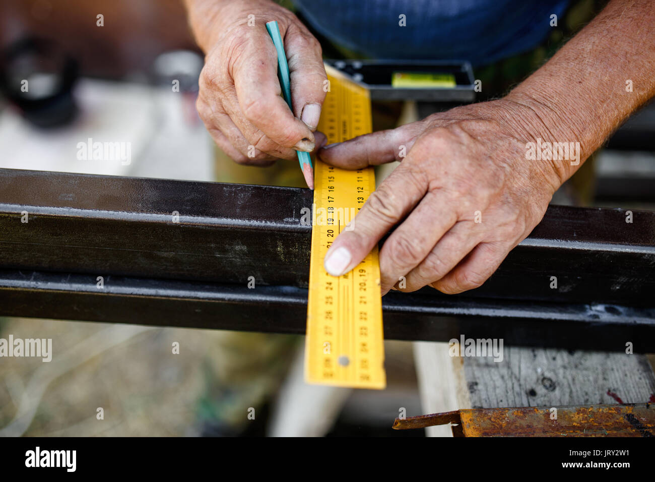 Mann messen aus Metall bar in der Werkstatt. Stockfoto