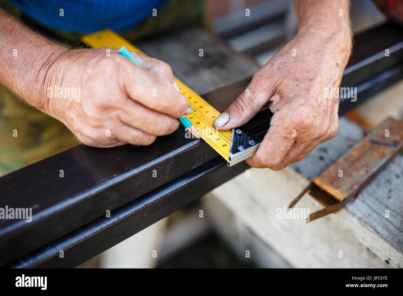 Mann messen aus Metall bar in der Werkstatt. Stockfoto