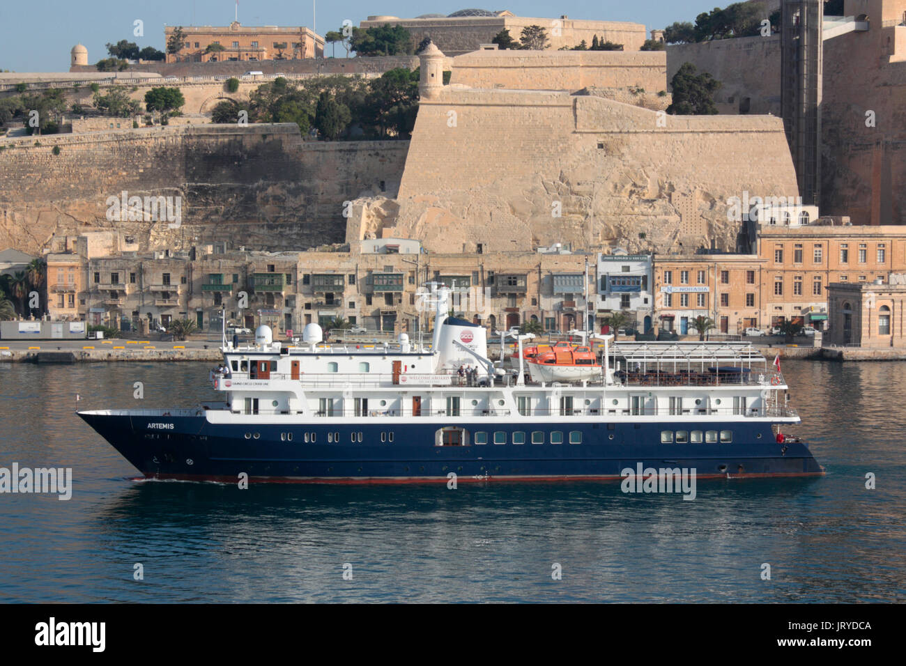 Die Grand Circle Cruise Line Schiff MV Artemis unter der Befestigungsanlagen von Valletta, Malta's Grand Harbour gelangt Stockfoto