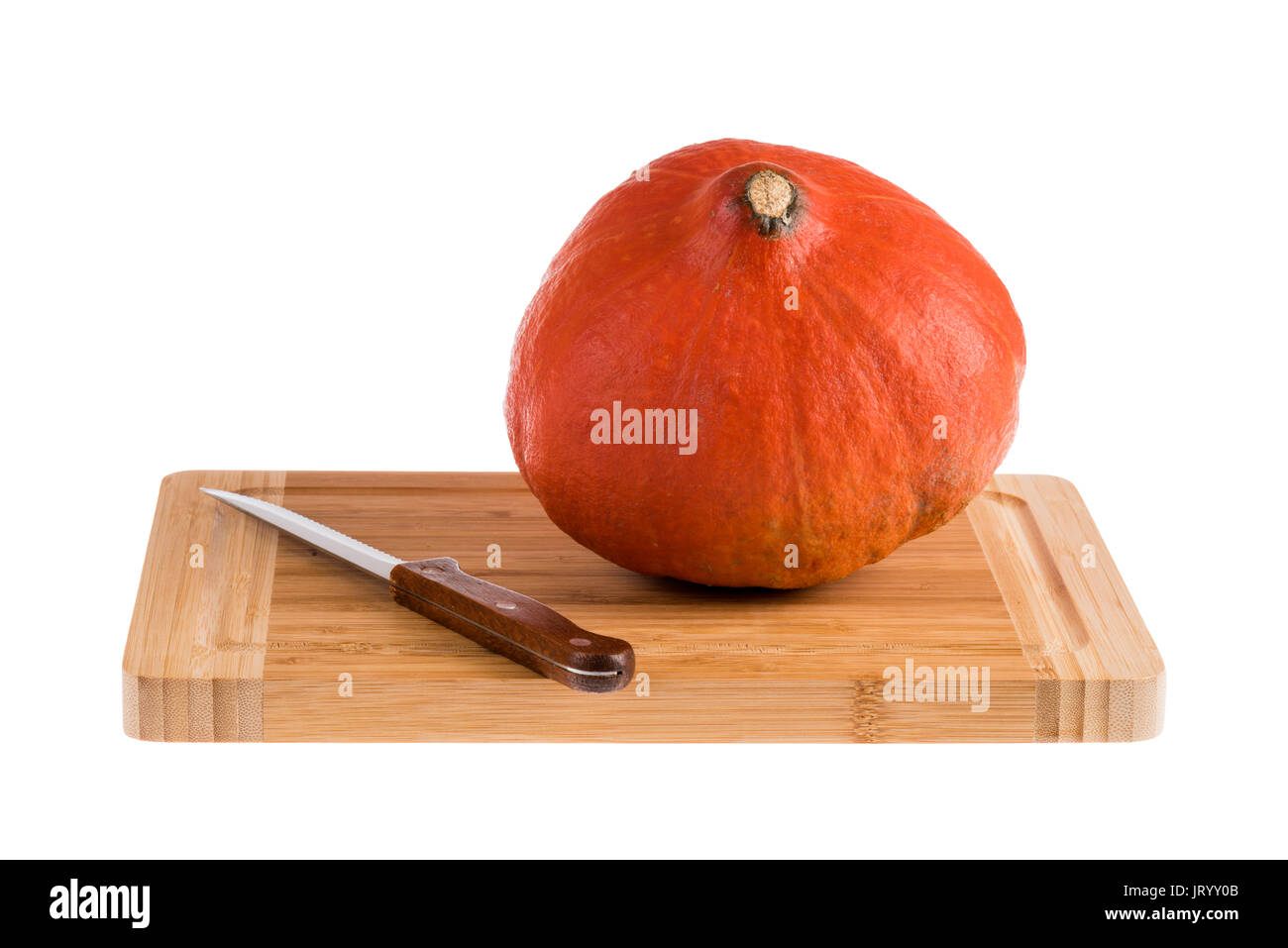 Eine orange Kürbis auf einer hölzernen Schneidebrett mit Messer, auf einem weißen Hintergrund. Stockfoto
