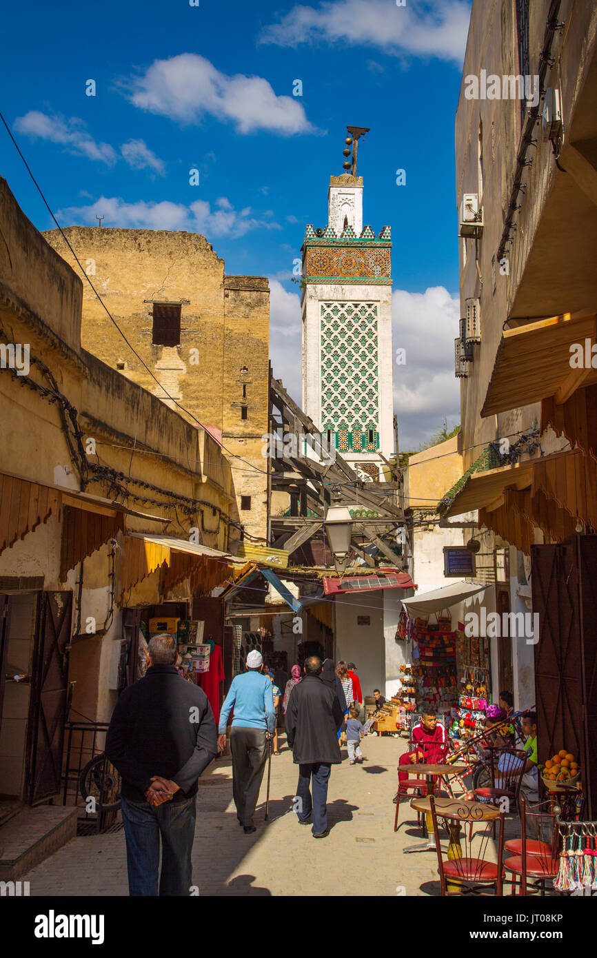 Die Medersa Bou Inania Minarett. Das Leben auf der Straße. Souk Medina von Fes, Fes el Bali. Marokko, Maghreb Nordafrika Stockfoto