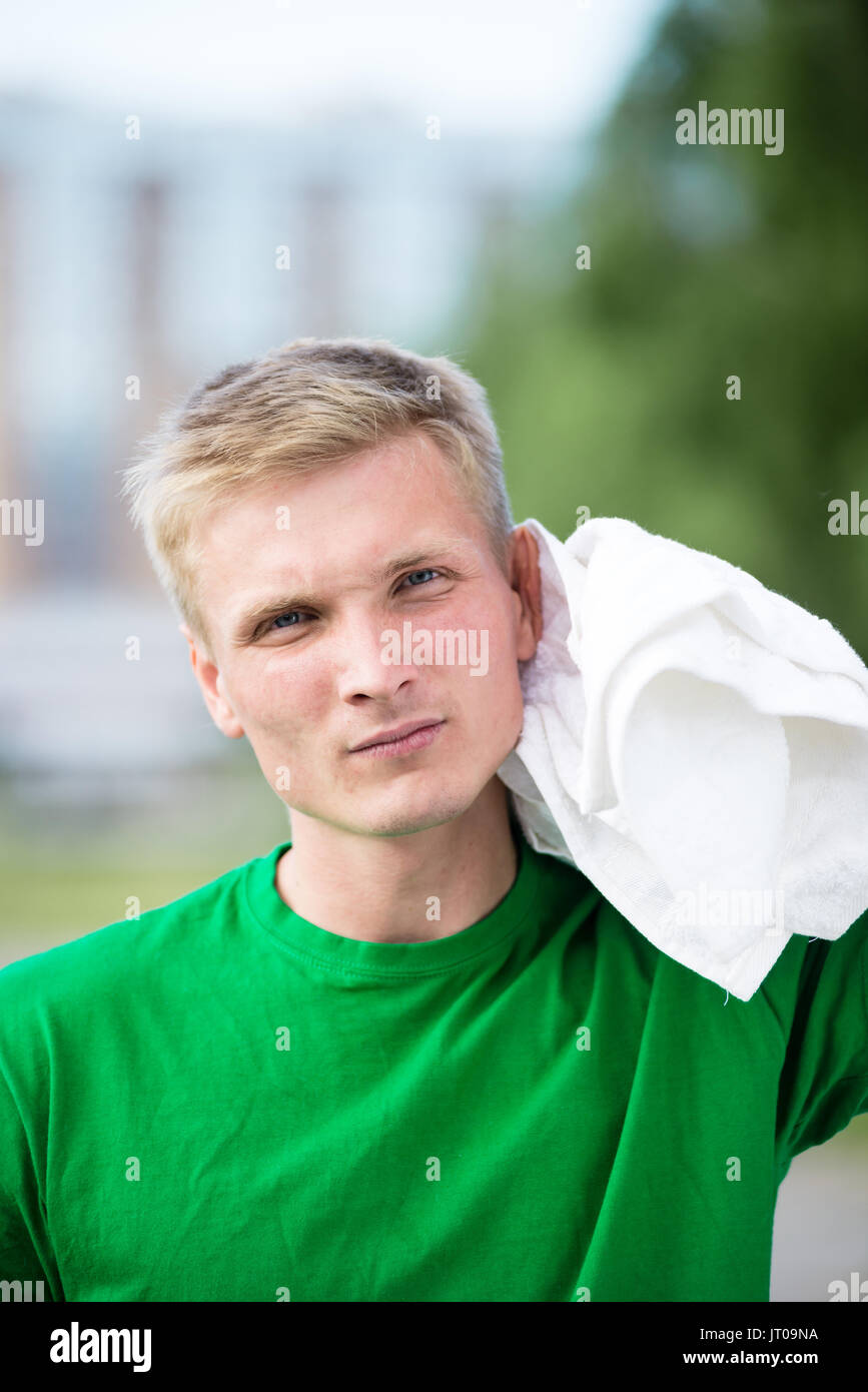 Müde Mann mit weißen Handtuch nach Fitness und Training in city street Park am schönen Sommertag. Sportliches Modell kaukasischen Ethnie Organisationseinheit Schulung Stockfoto