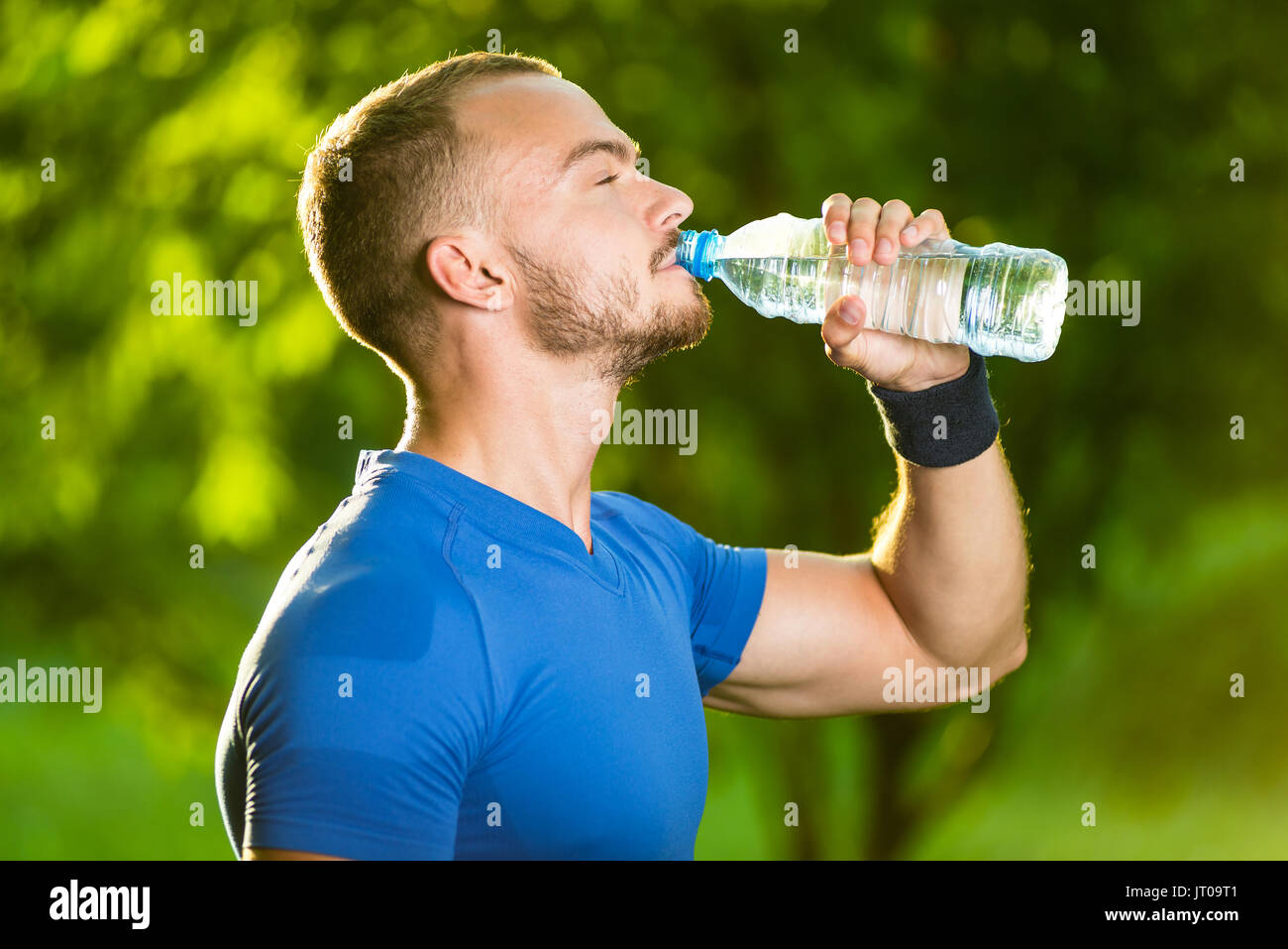 Athletische Sportart Man Trinkwasser aus der Flasche. Kaltes Getränk nach outdoor-Fitness. Stockfoto