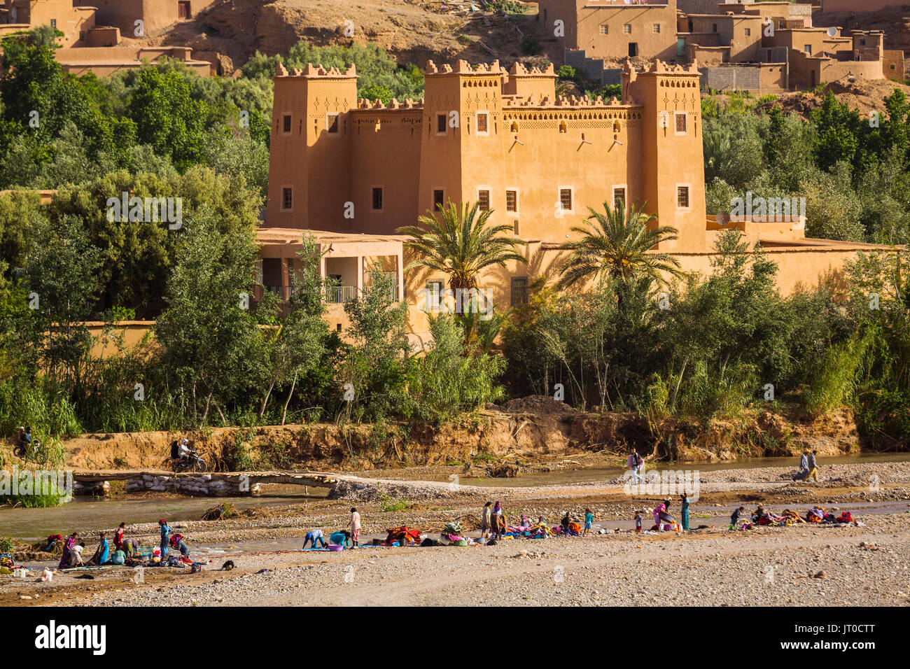 Frauen und Kinder Wäsche Waschen im Fluss, Kalaat M'Gouna, Tal der Rosen. Marokko, Maghreb Nordafrika Stockfoto