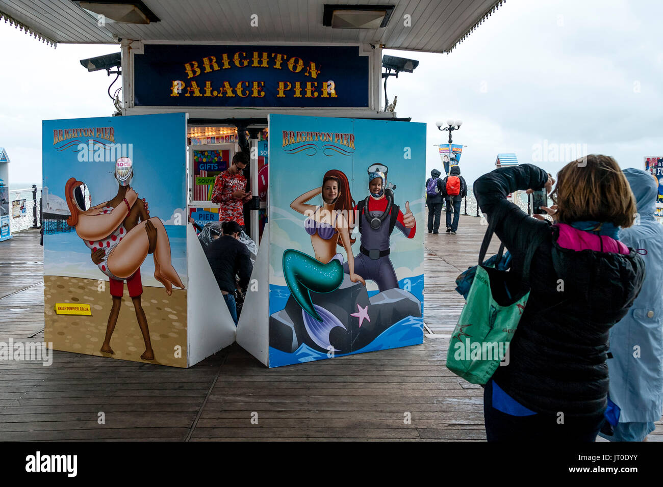 Menschen Posieren für Bilder, die aus einer Fläche Ausschneiden, Pier von Brighton, Brighton, Sussex, UK Suchen Stockfoto