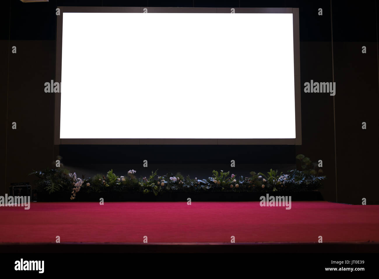 Leere Leinwand auf der Bühne mit roten Teppich im Konferenzsaal. Stockfoto