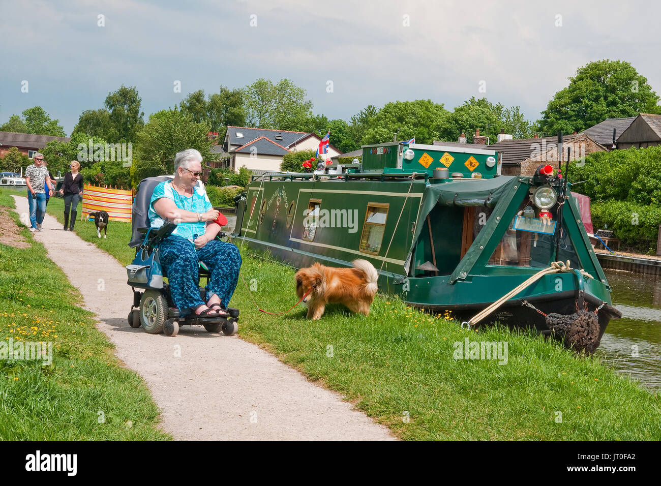 Boote und Hund Spaziergänger auf dem Lancaster Canal an Bilsborrow, Lancashire Stockfoto