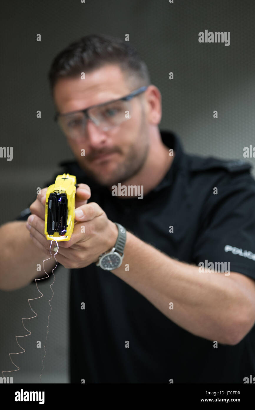 Polizei Sgt Ivan Merc aus den West Midlands Arme Feuereinheit veranschaulicht, wie die neue X2 Taser, die in den West Midlands, ersetzen Sie die aktuellen X26 ausgerollt Modell. Stockfoto