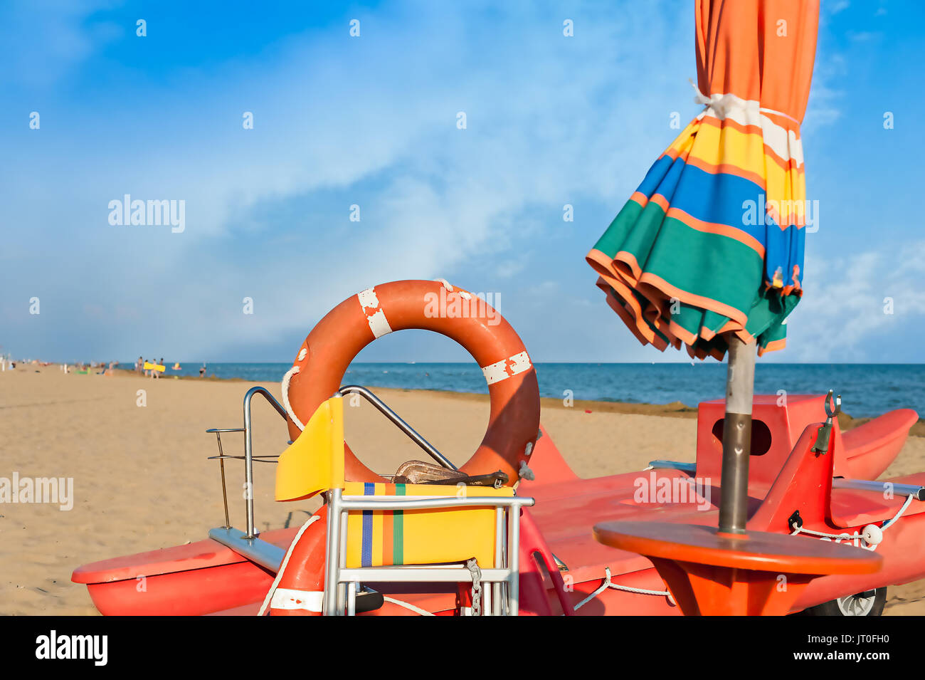 Lifeguard Tools, Regenschirm, Rettungsring und Rettung Boot gegen Strand, Meer und Himmel Stockfoto
