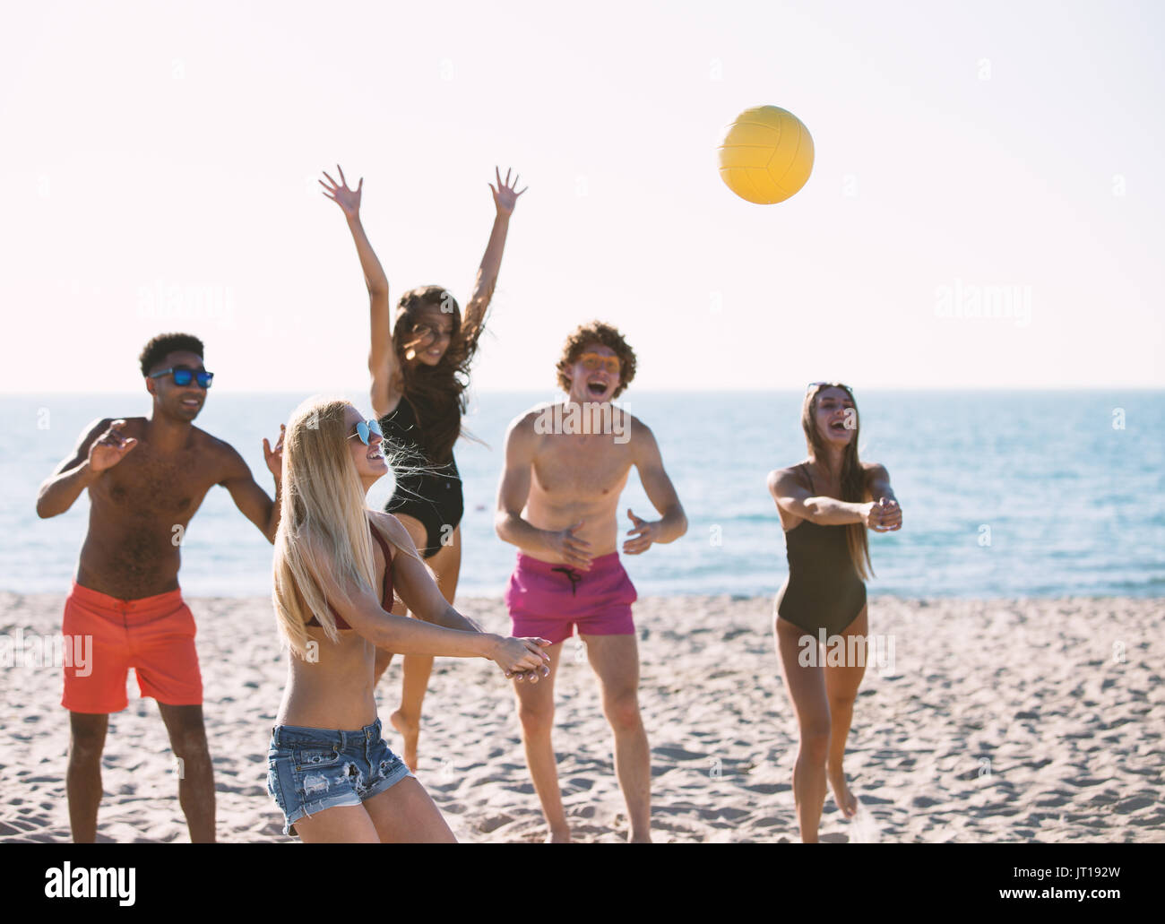 Gruppe von Freunden zu Beach-Volleyball am Strand spielen Stockfoto