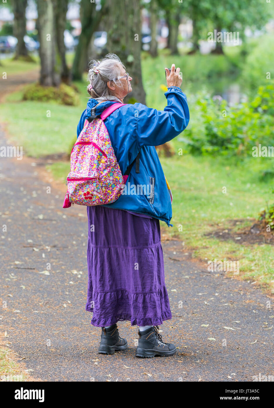 Ältere Frau mit einem Rucksack Fotos machen. Stockfoto