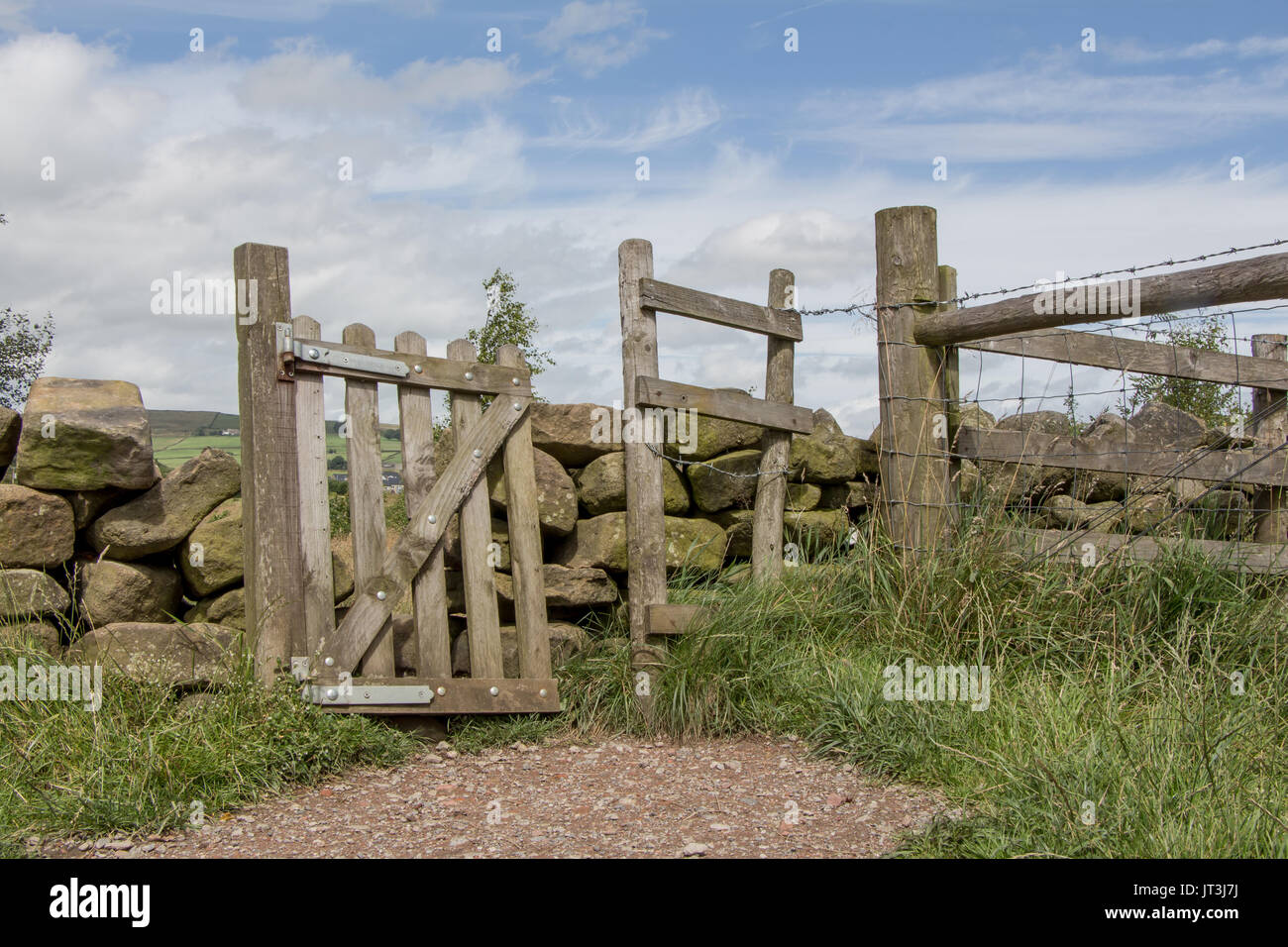 Ein rustikales, schrägen hölzerne Tor in einem traditionellen Stein Wand zwischen Feldern in den ländlichen Lancashire Landschaft. Stockfoto