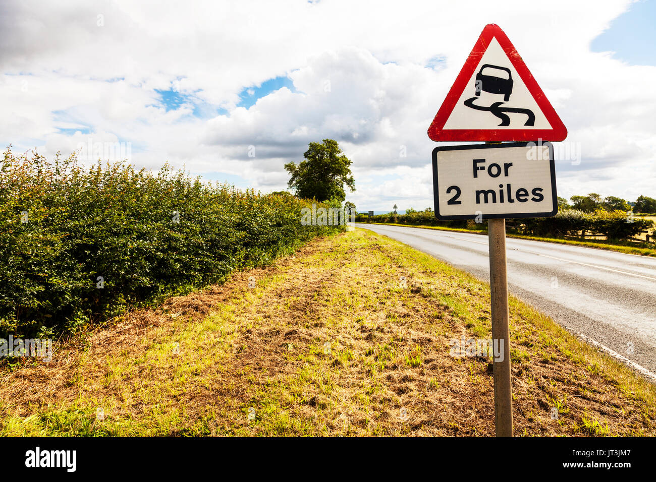 Wildwechsel, Wildwechsel UK Straßenschild für 2 Meilen, rutschige Straße für 2 Meilen, Straßenschild, Warnung, Gefahr, Vorsicht, UK, England, UK-Verkehrszeichen Stockfoto