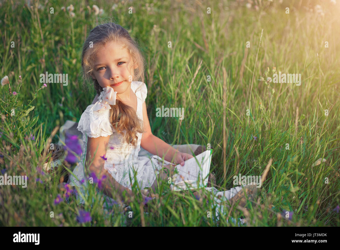 Niedliche kleine Mädchen Buch auf Natur Stockfoto