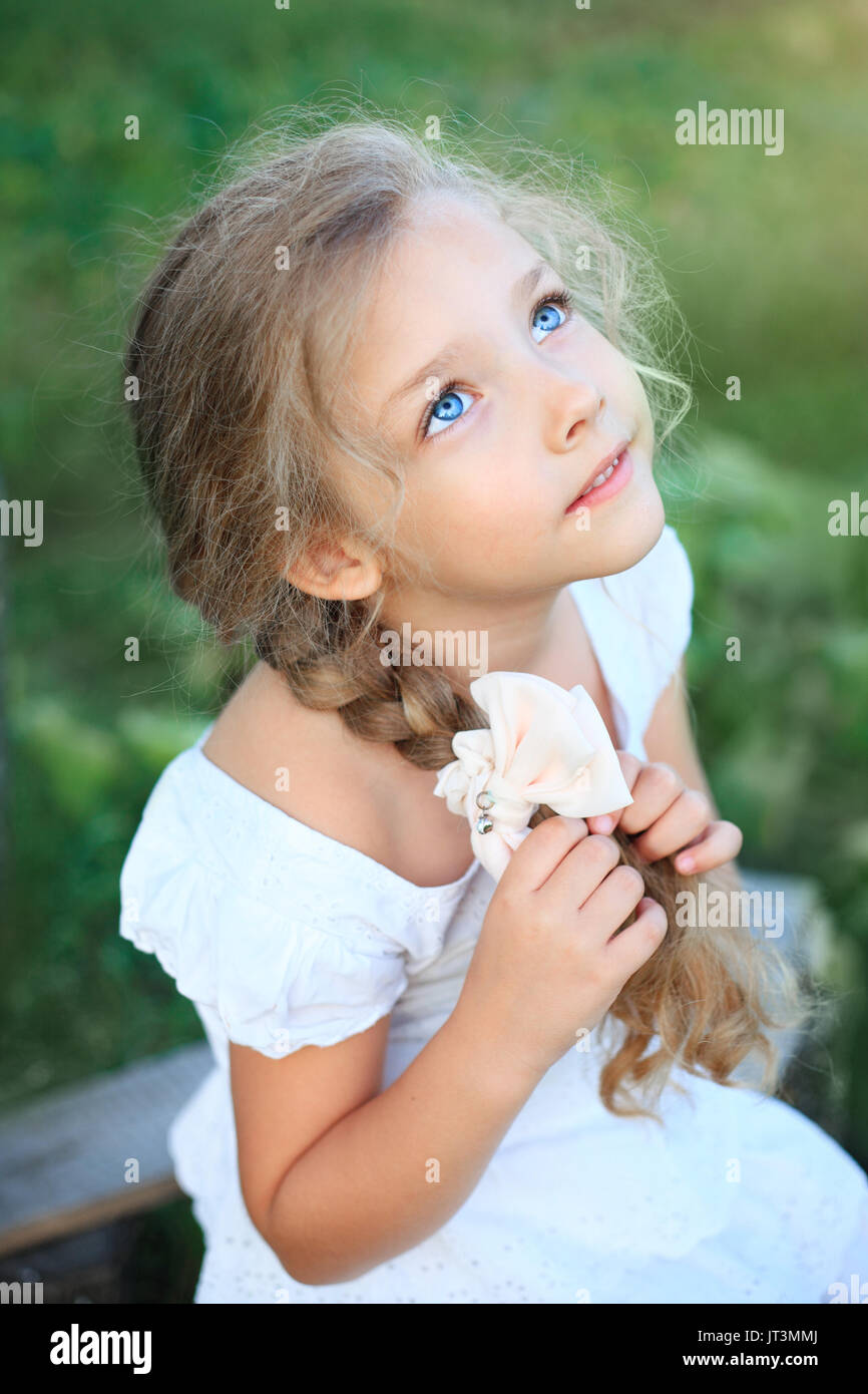 Süße kleine Mädchen auf Natur in hellen Sommertag suchen Stockfoto