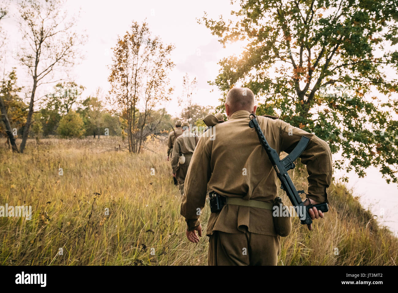 Gruppe von Reenactors Männer verkleidet als russisch-sowjetischen Roten Armee Infanterie Soldaten des Zweiten Weltkriegs marschieren im Herbst Feld mit Waffen zu historischen Reena Stockfoto